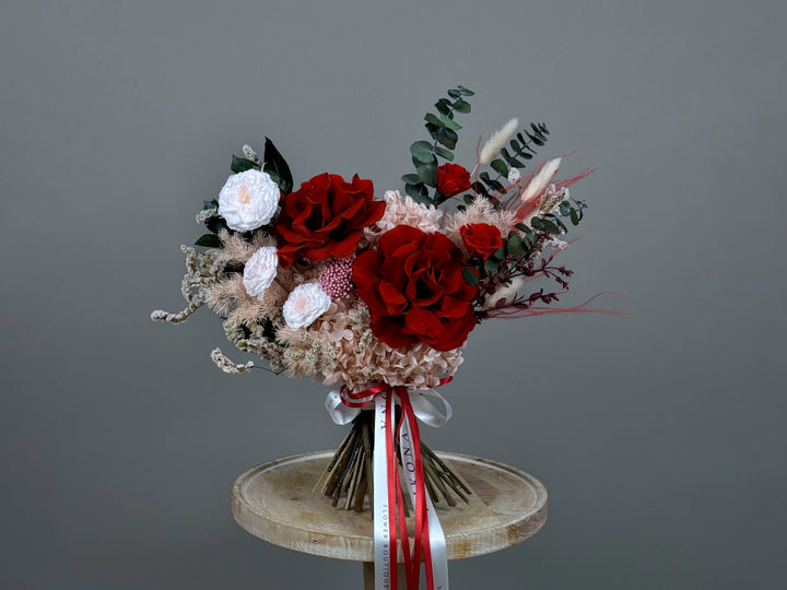 "Bold red and white bouquet with eucalyptus and ribbon by MIKONA Flowers"
