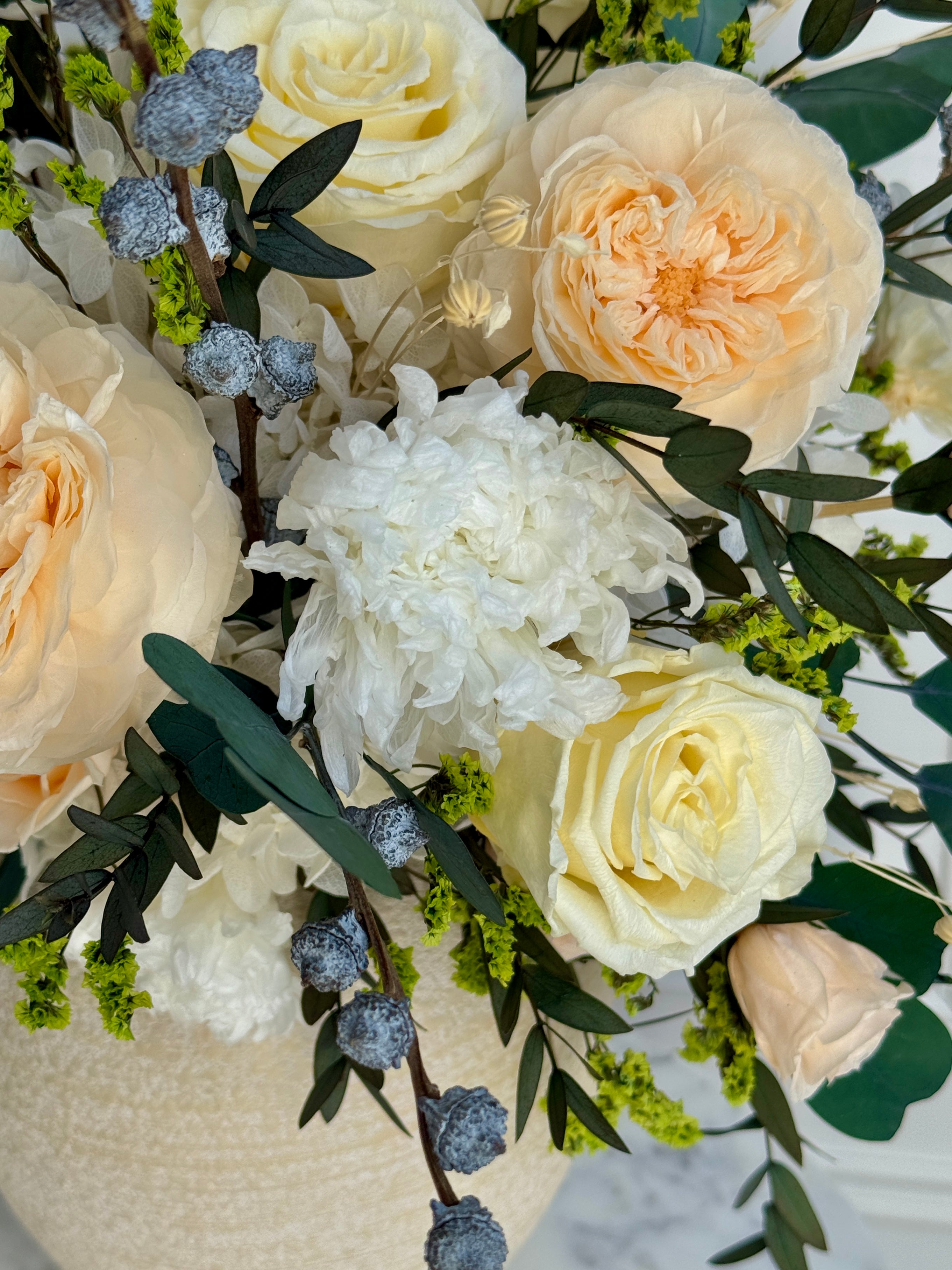 Ivory and blush eternal roses in ceramic vase