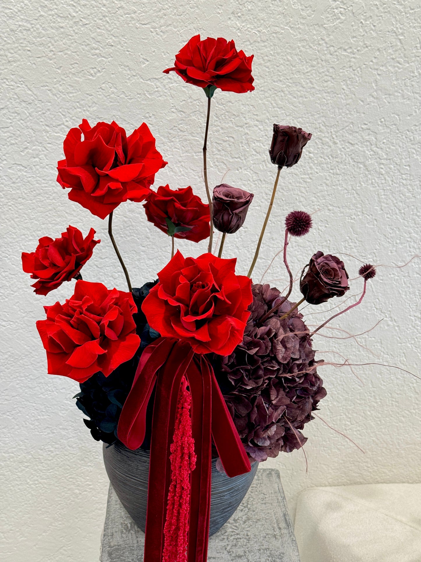 Red and plum preserved roses arrangement with vase